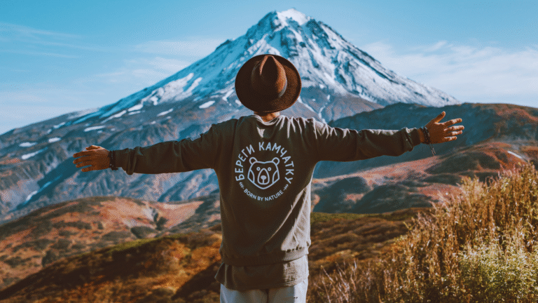 A person enjoying a snowy landscape in front of a mountain, symbolizing adventure and safe travel with Faye Travel Insurance.