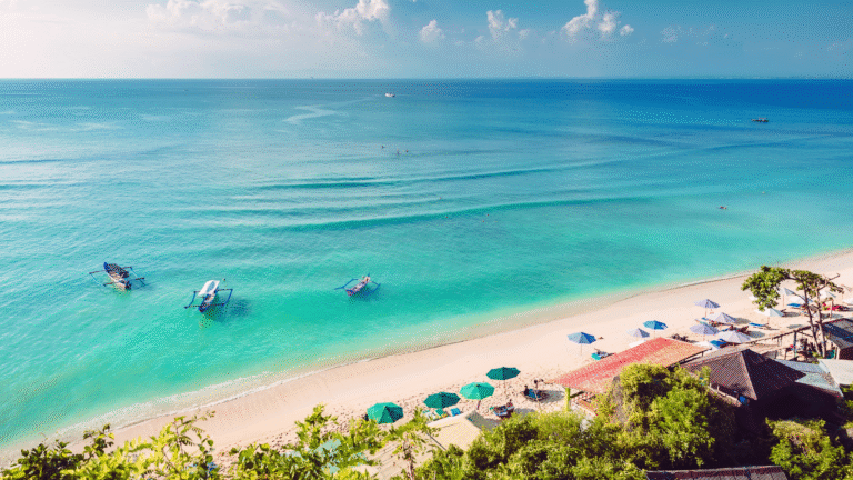 Sunset view of Kuta Beach in Bali, Indonesia with surfers, golden sand, and vibrant nightlife – one of the Top 10 Asian Beaches