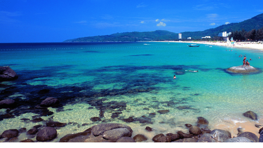 Aerial view of tropical Phuket beaches in Thailand with turquoise waters, palm trees, and soft sand – a popular travel destination and one of the Top 10 Asian Beaches

