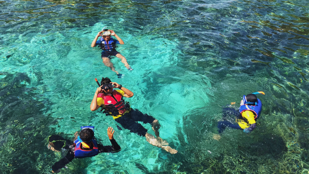 Four people preparing to dive into the ocean at a top Caribbean dive destination.

